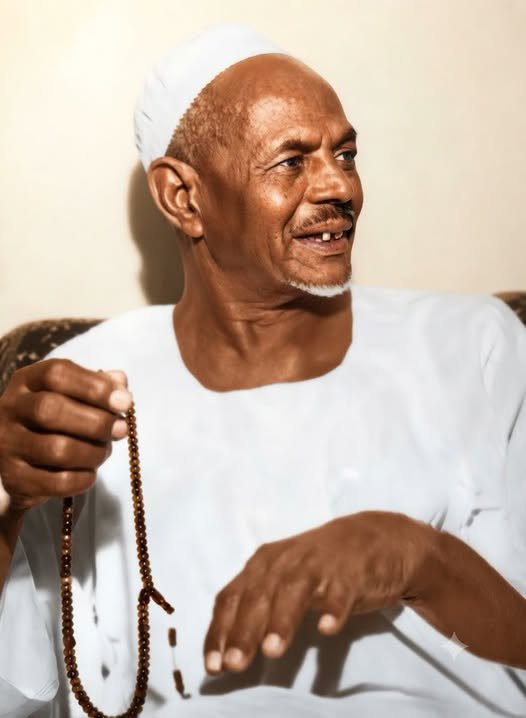 الشيخ محمد عثمان عبده البرهاني مبتسمًا وبيده السبحة