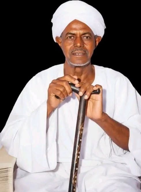 الشيخ محمد عثمان عبده البرهاني جالسًا متكئًا على عصاه